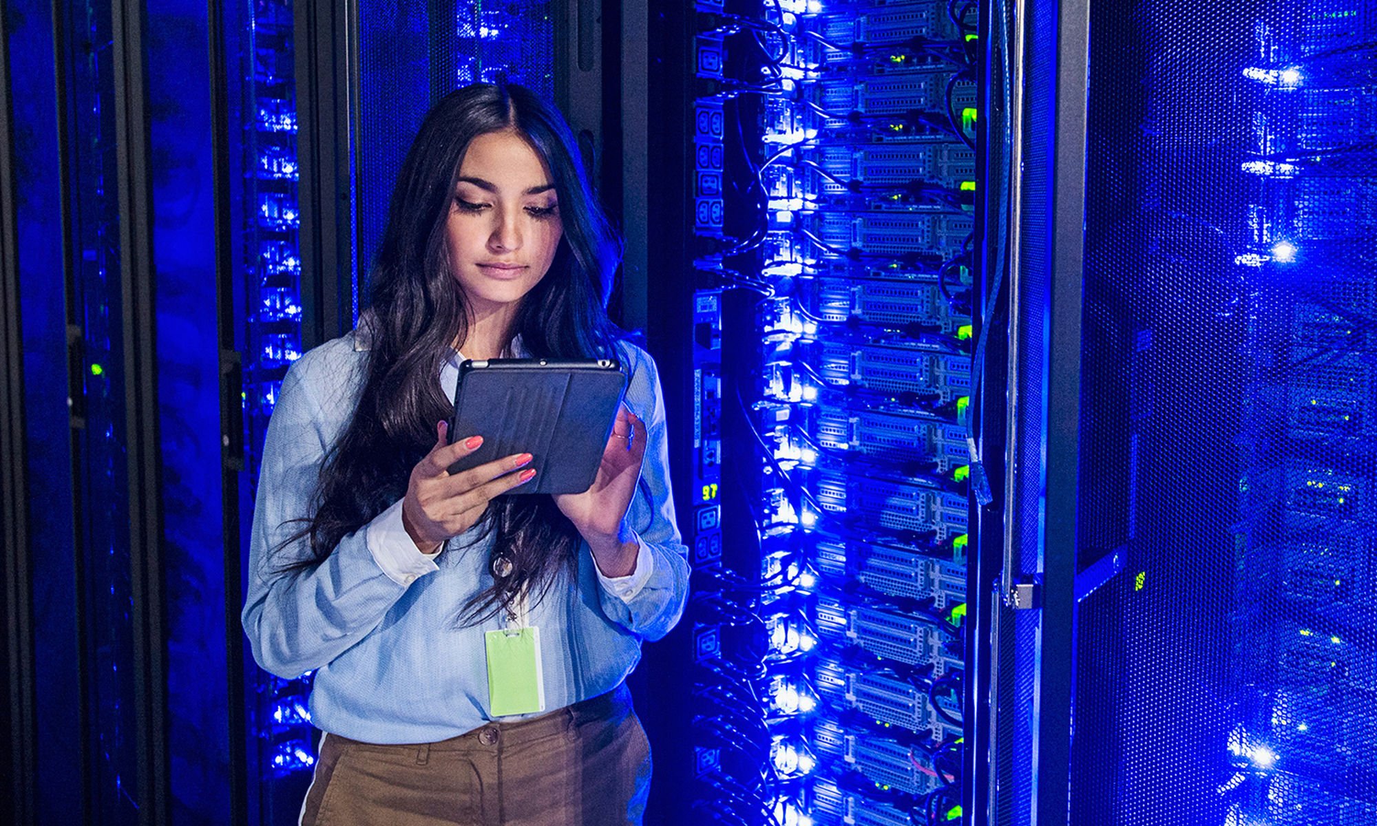 women seeing at the device she holding in the hand in the data center 