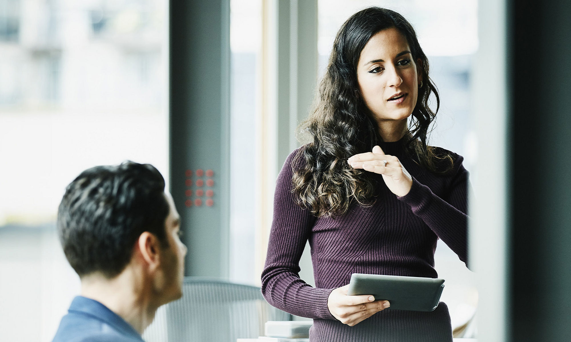 Women speaking to collegues with a tablet in hand