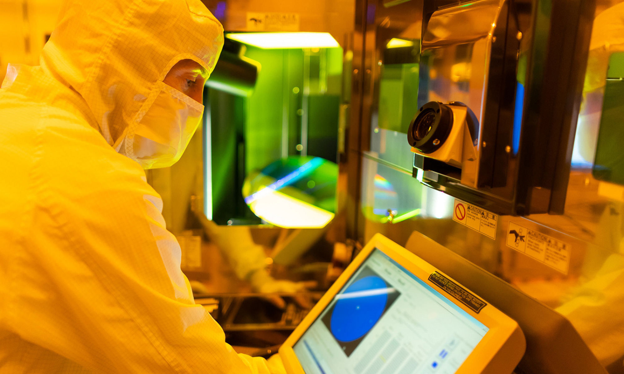 Engineer working in the lab and looking at a wafer on a monitor