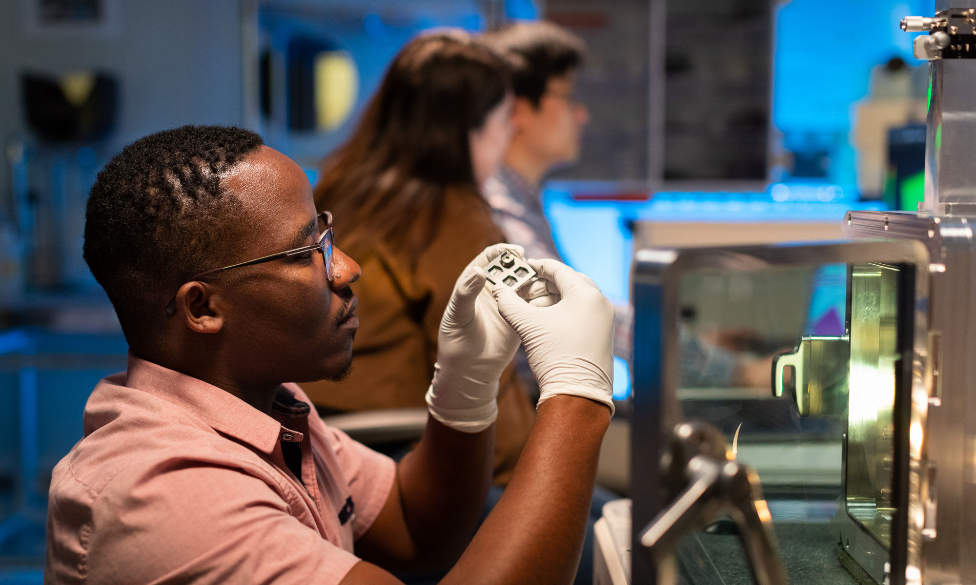 Person taking a close look at a device wearing gloves