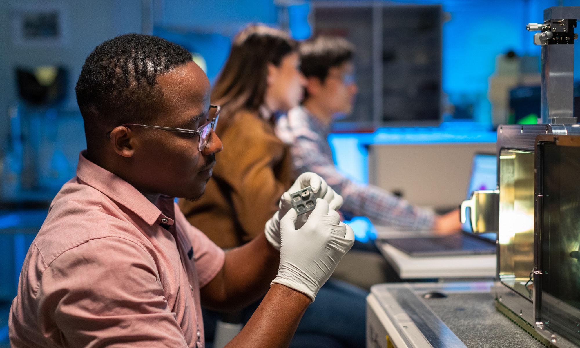 Surface analytics lab worker inspecting a part