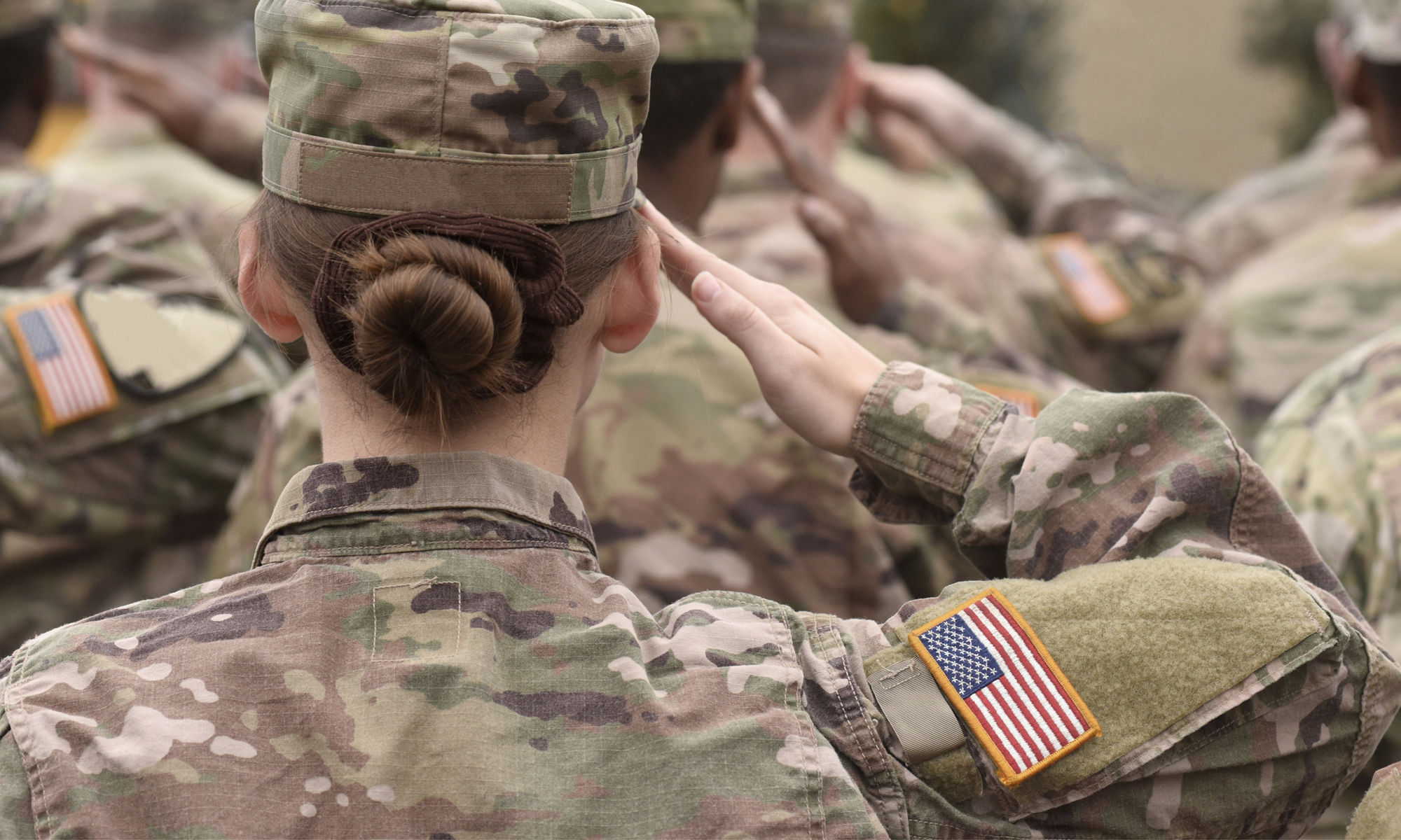 Army woman salutes with her troop