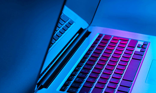 An opened laptop with purple and blue lights