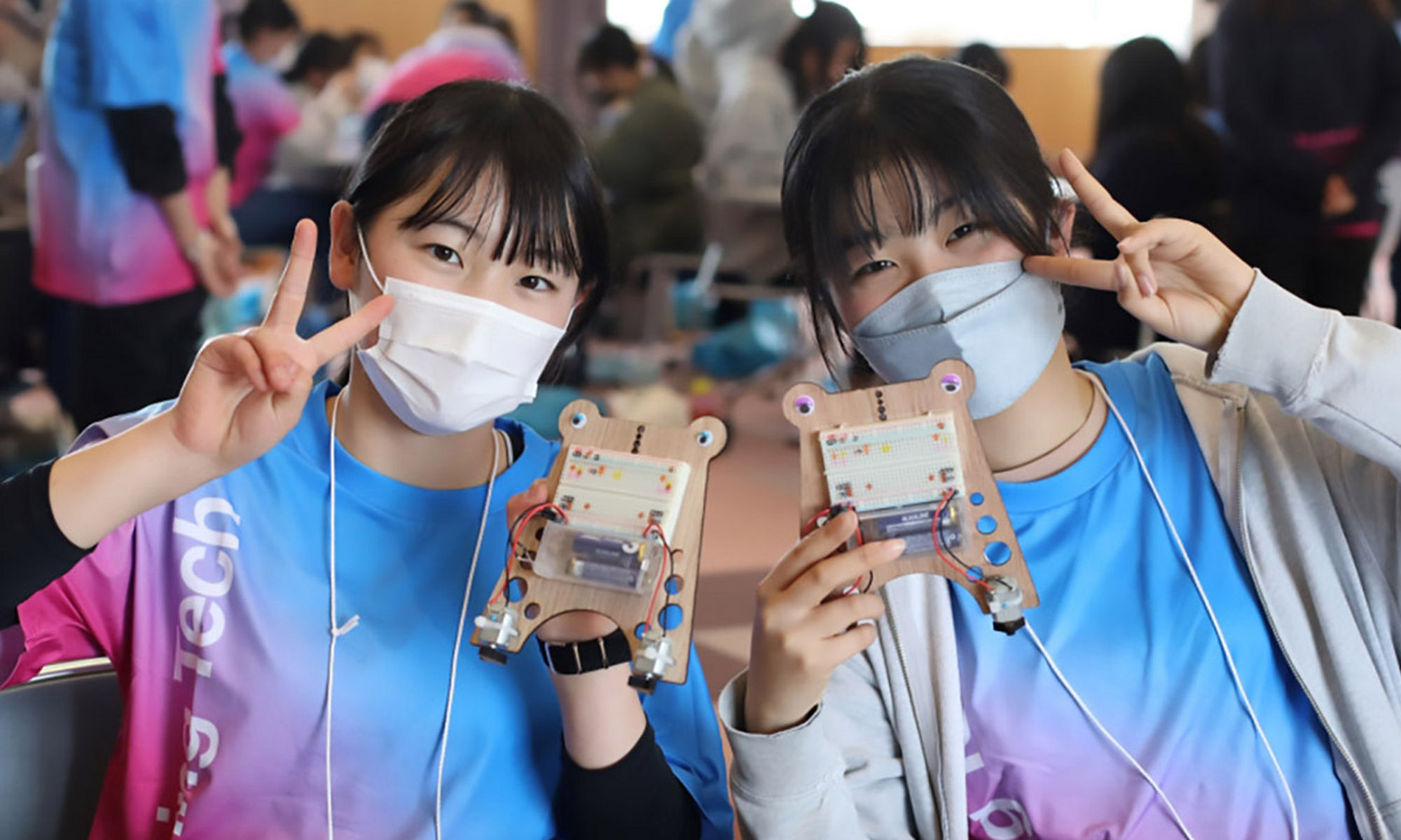 Two women wearing mask holding stem project in their hand