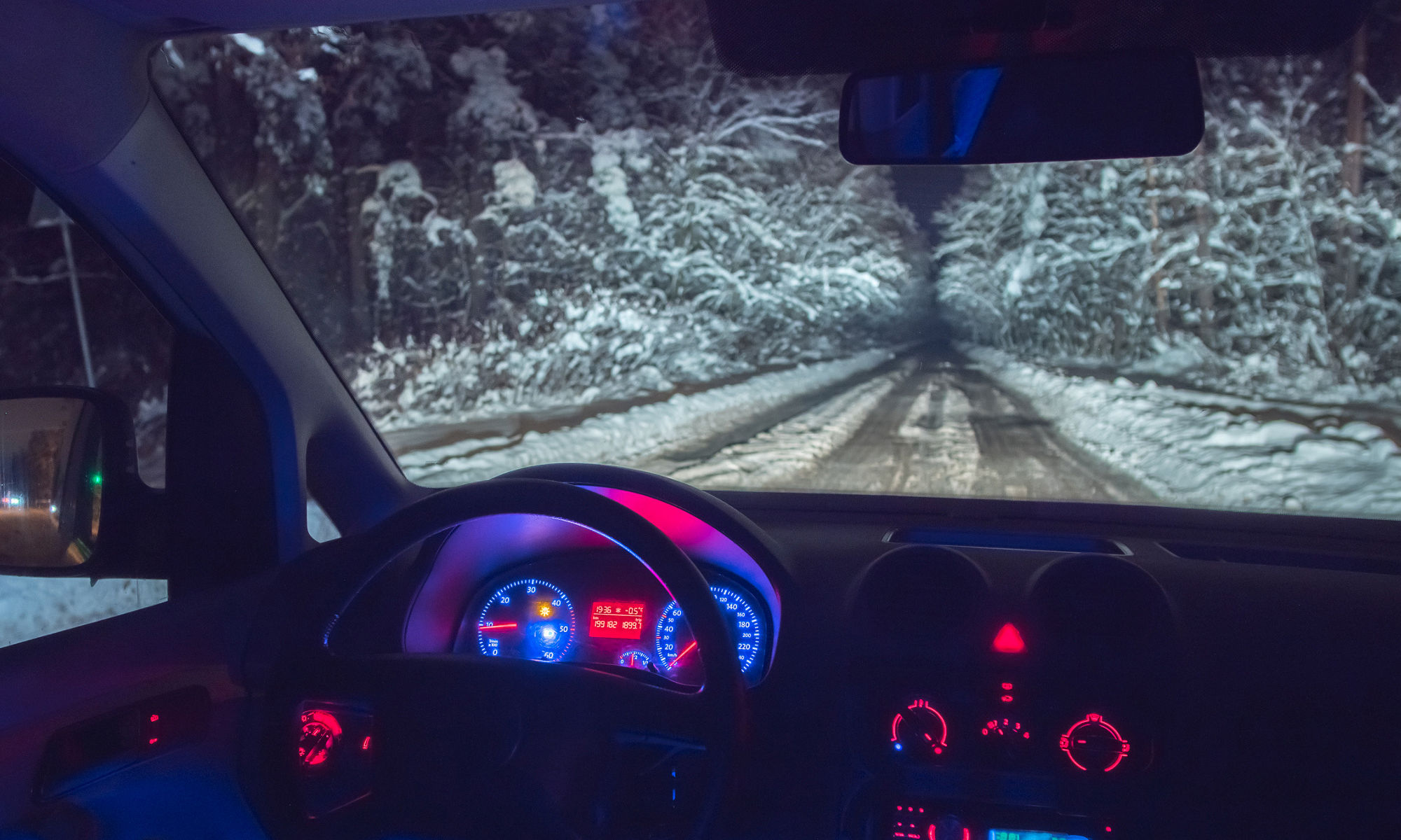 在森林道路上的汽車內部。晚上