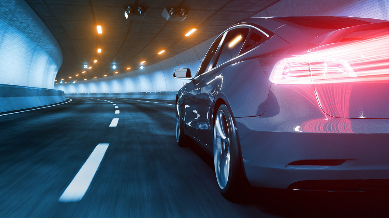 High performance car driving through curved tunnel