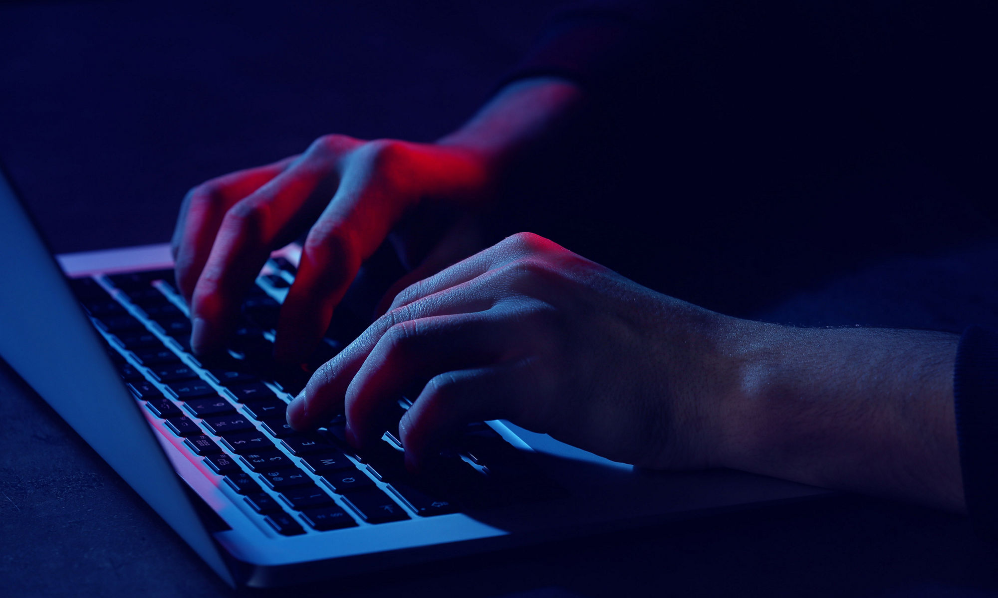 暗い背景の中でキーボードを打つ人物