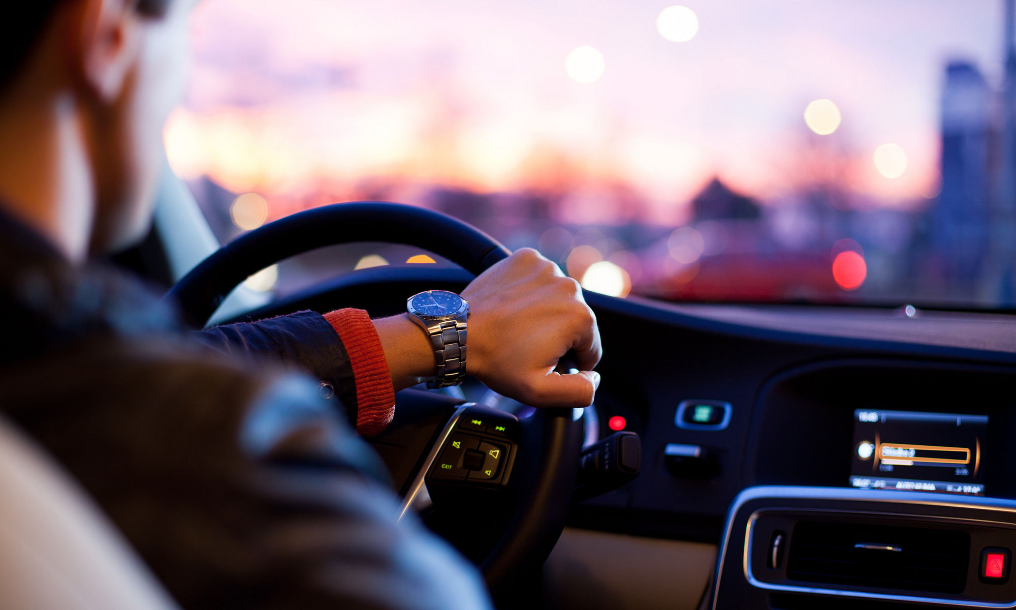 Driving a car at night - pretty, young woman driving her modern car at night in a city (shallow DOF; color toned image)