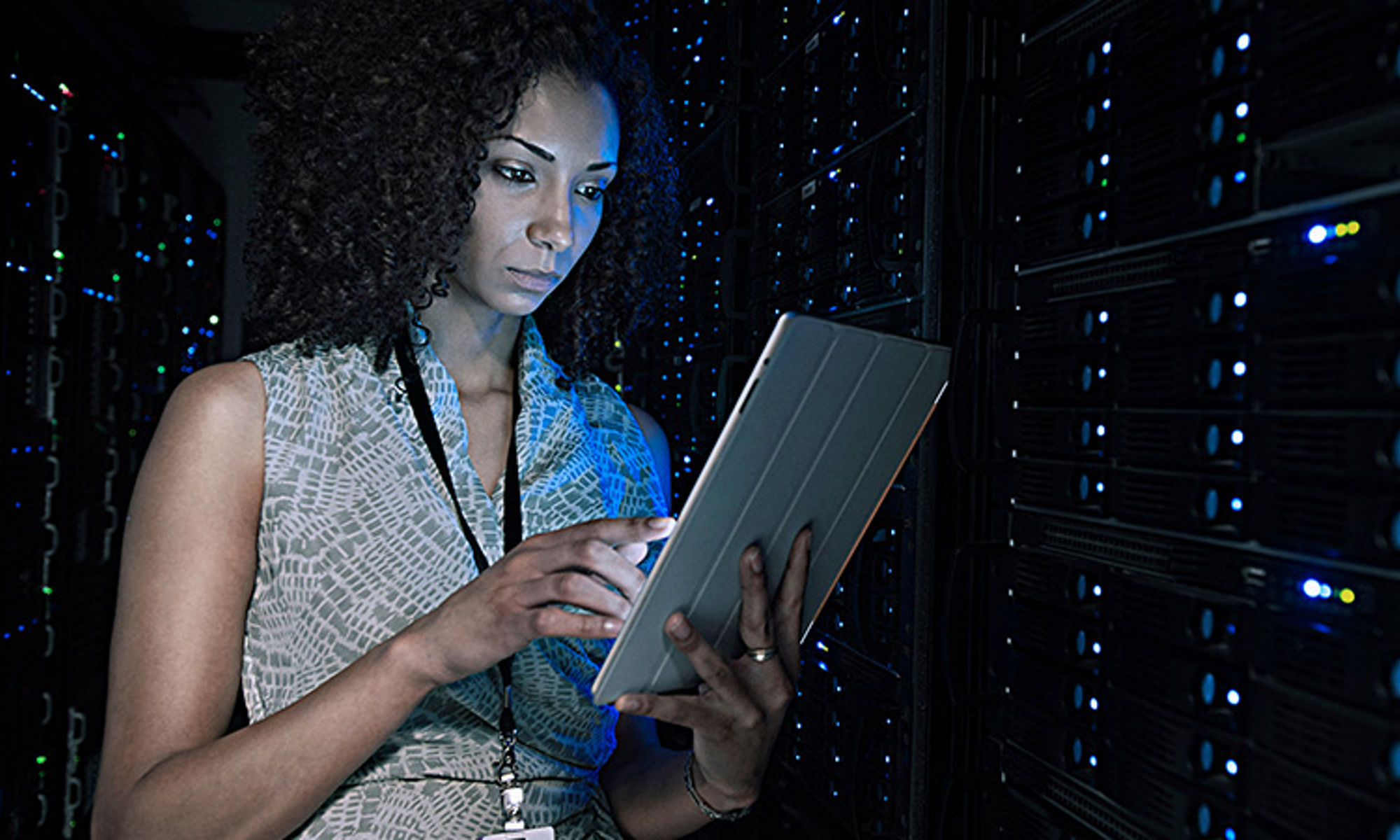 woman holding a laptop on a server room