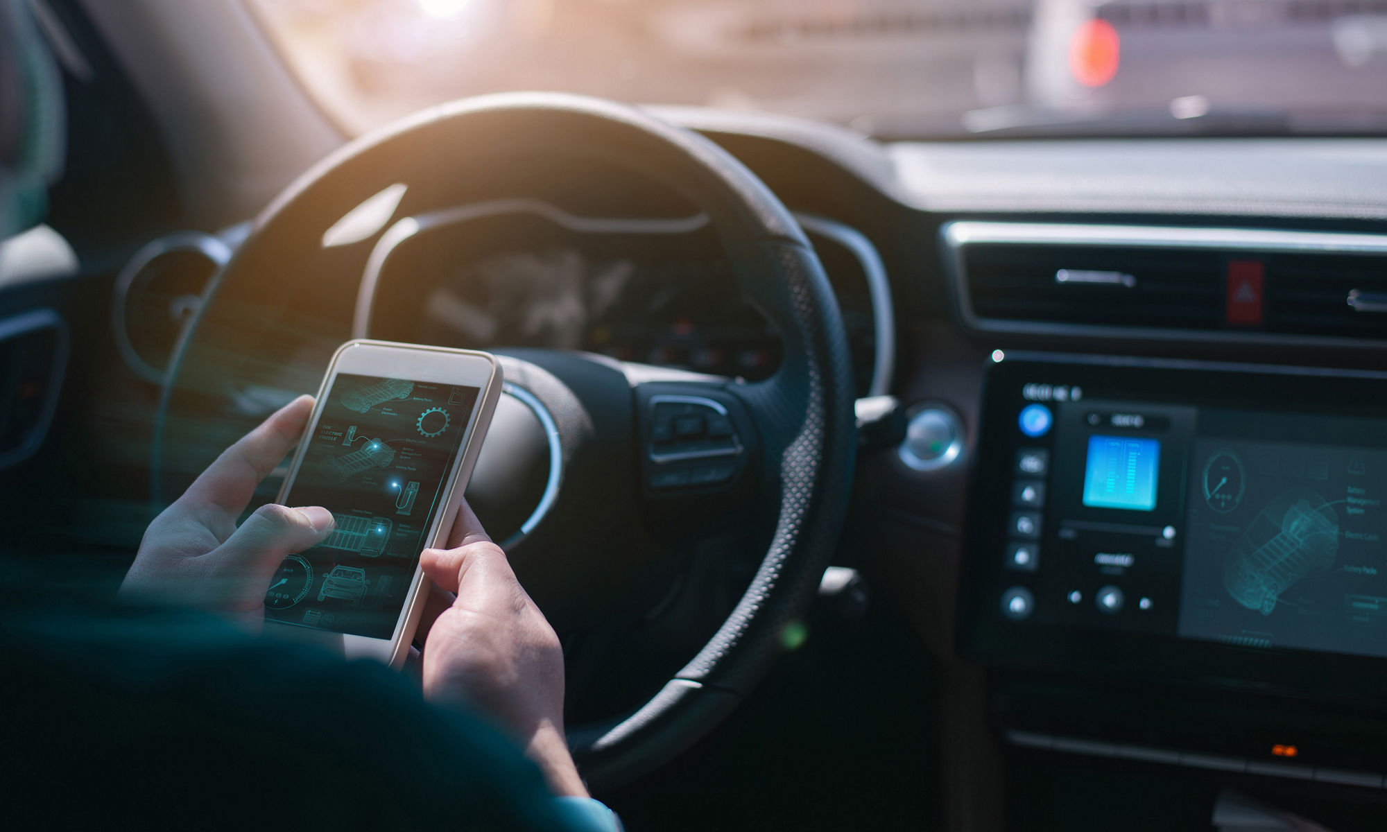 Driver sitting in a car looking at smartphone