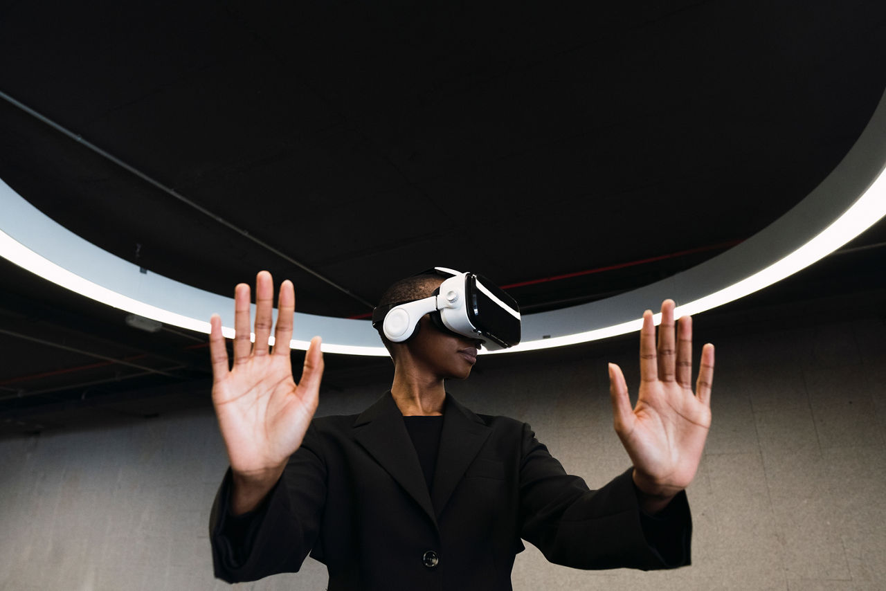 Young woman with VR glasses doing stop gesture in parking garage