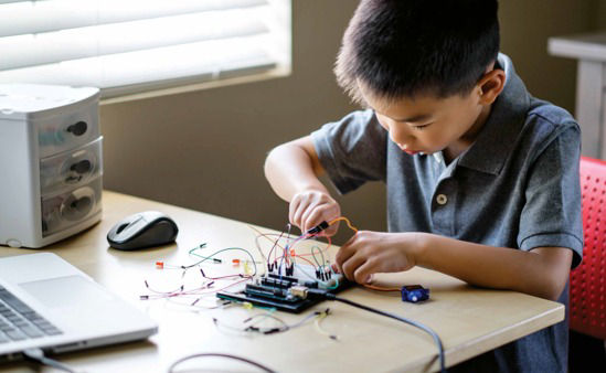 young boy building a circuit board