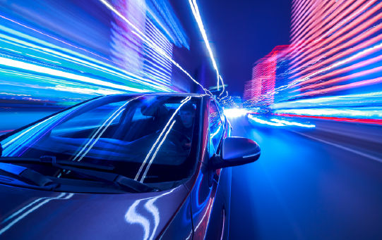 Front view of a vehicle with motion blurred lights of a city street