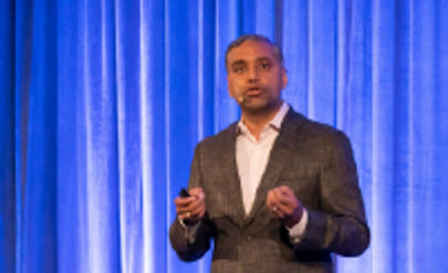 A person standing on stage addressing the audience