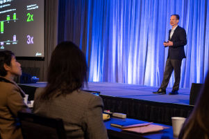 A person standing on stage addressing the audience