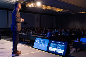 A person standing on stage addressing the audience