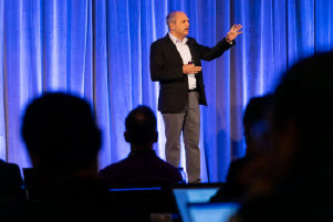 A person standing on stage addressing the audience