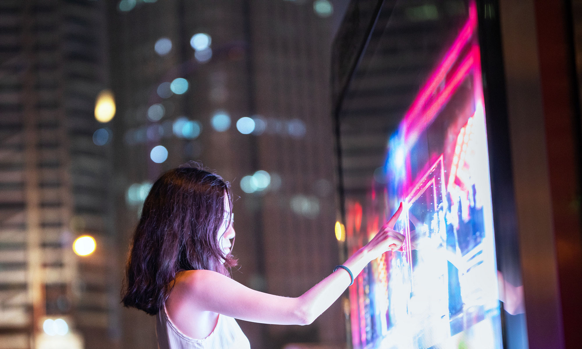 Young female using touch screen on the street