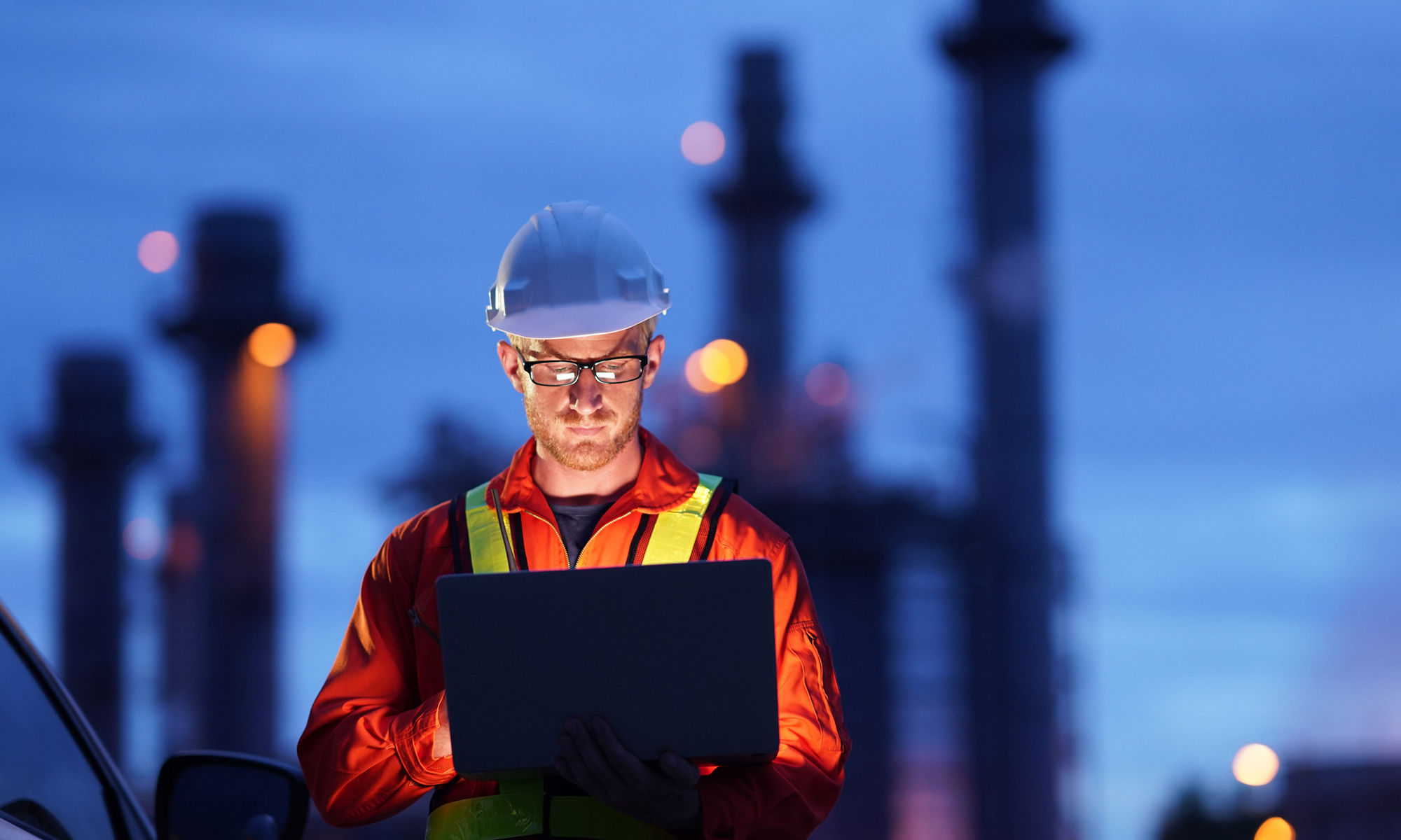 man in hardhat reading a laptop