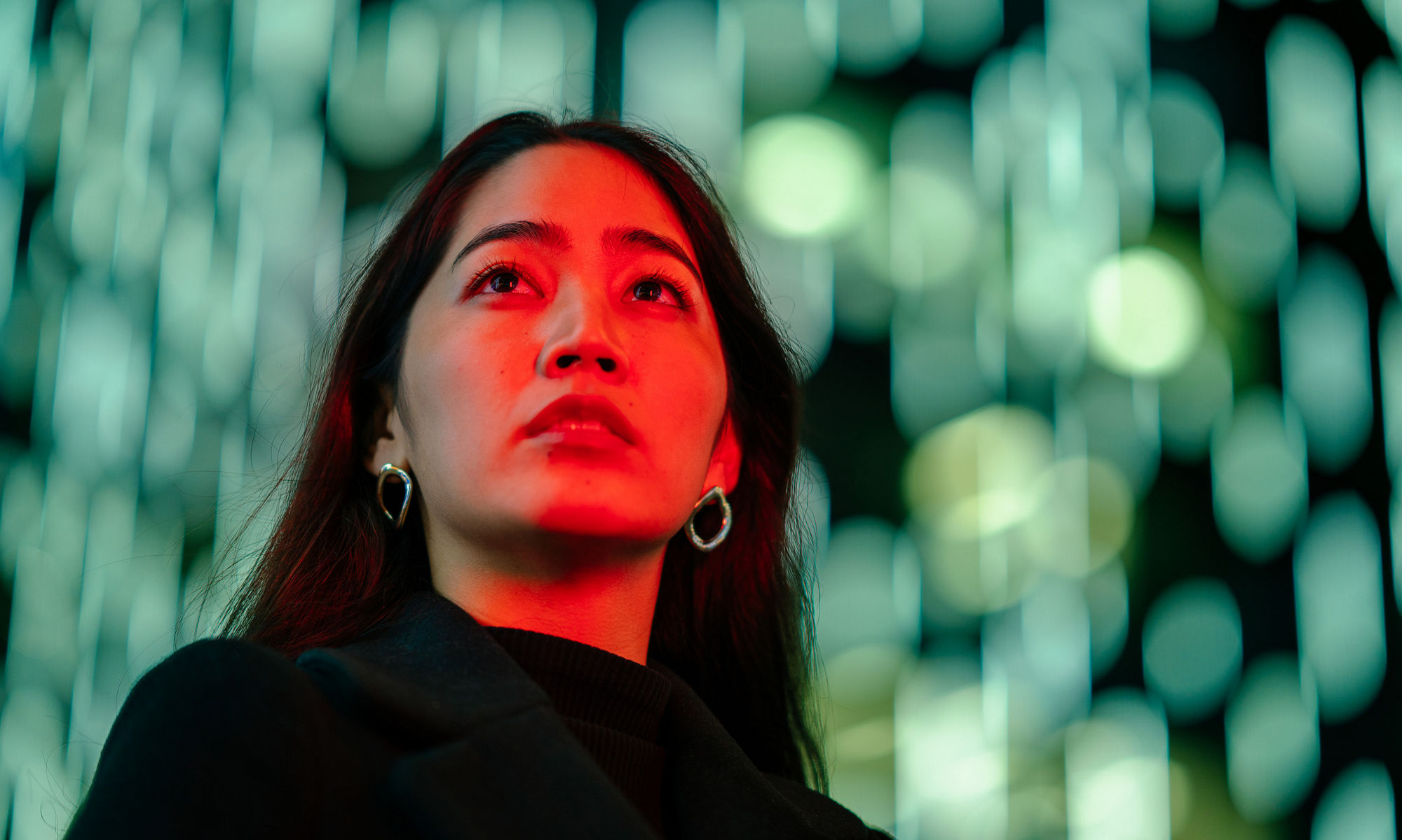 Young woman with blurred shimmering green lights in background