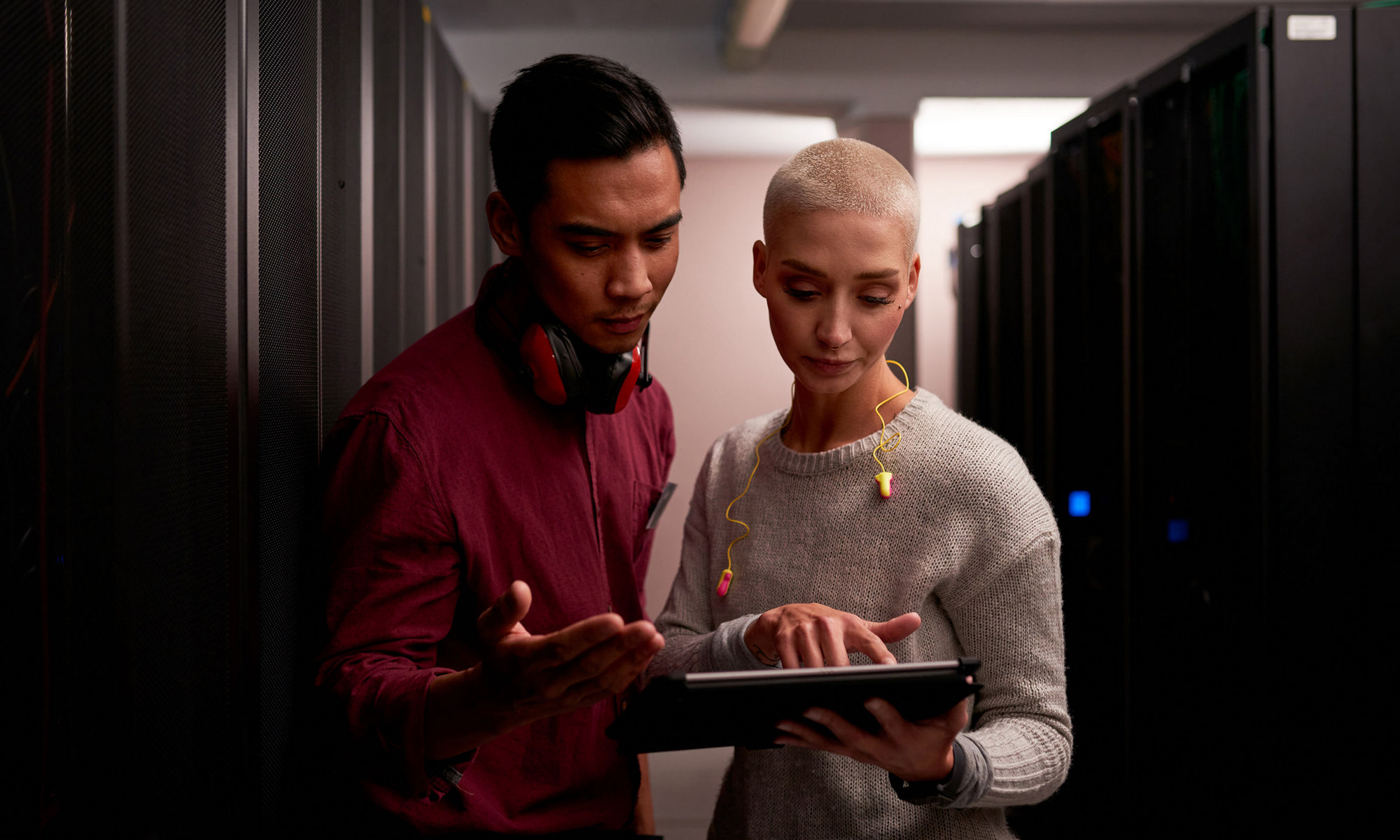 Man and woman looking at tablet device in data center