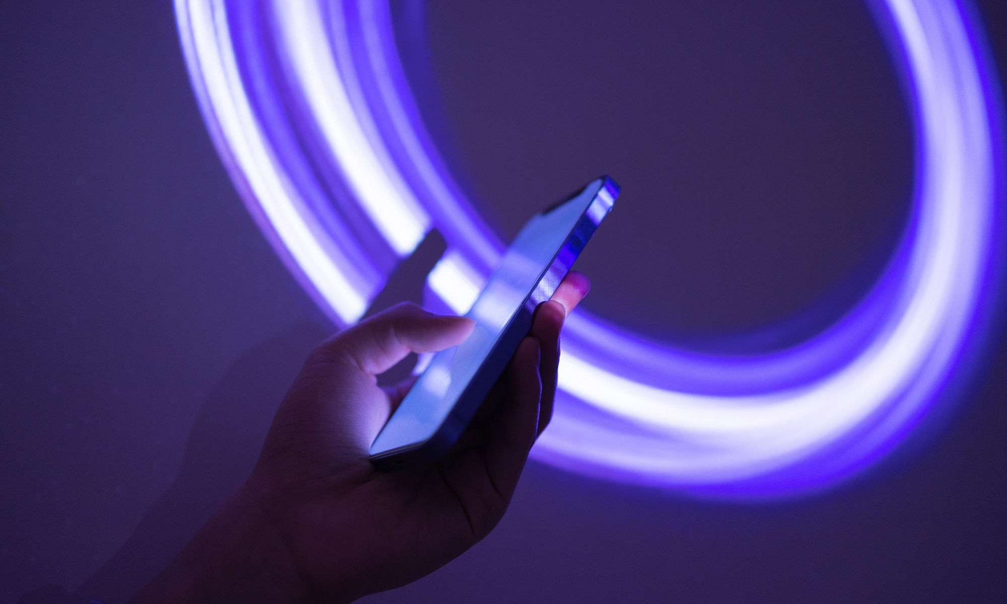 Phone being used with neon blue circular lines as background