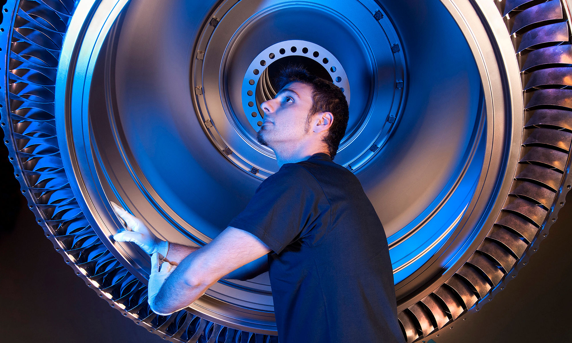 Man working on fan blades of a jet engine