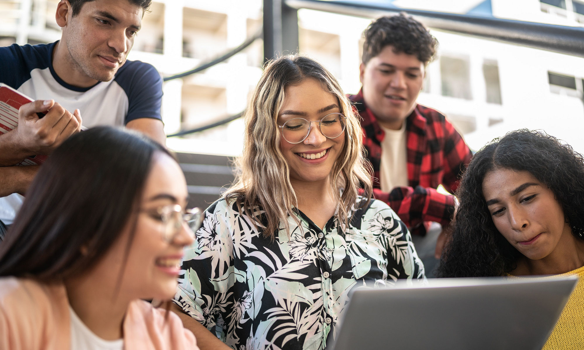 Group of students gathered around a laptop