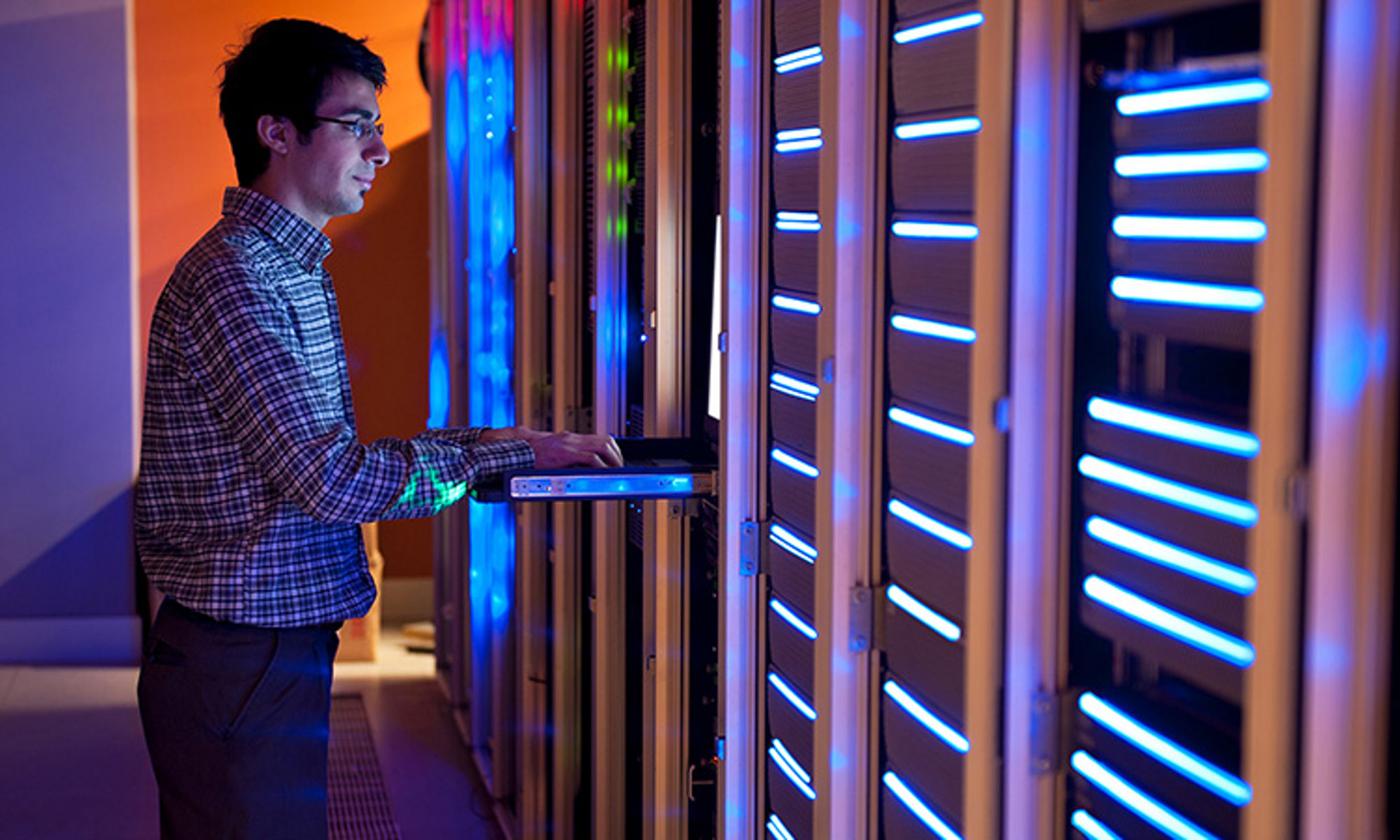 system admininstrator standing in front of server rack