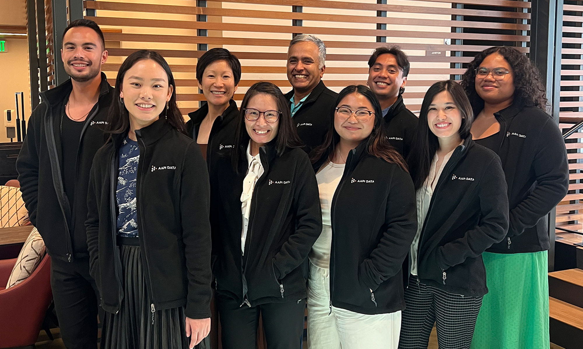 group of people wearing black jacket standing together look happy