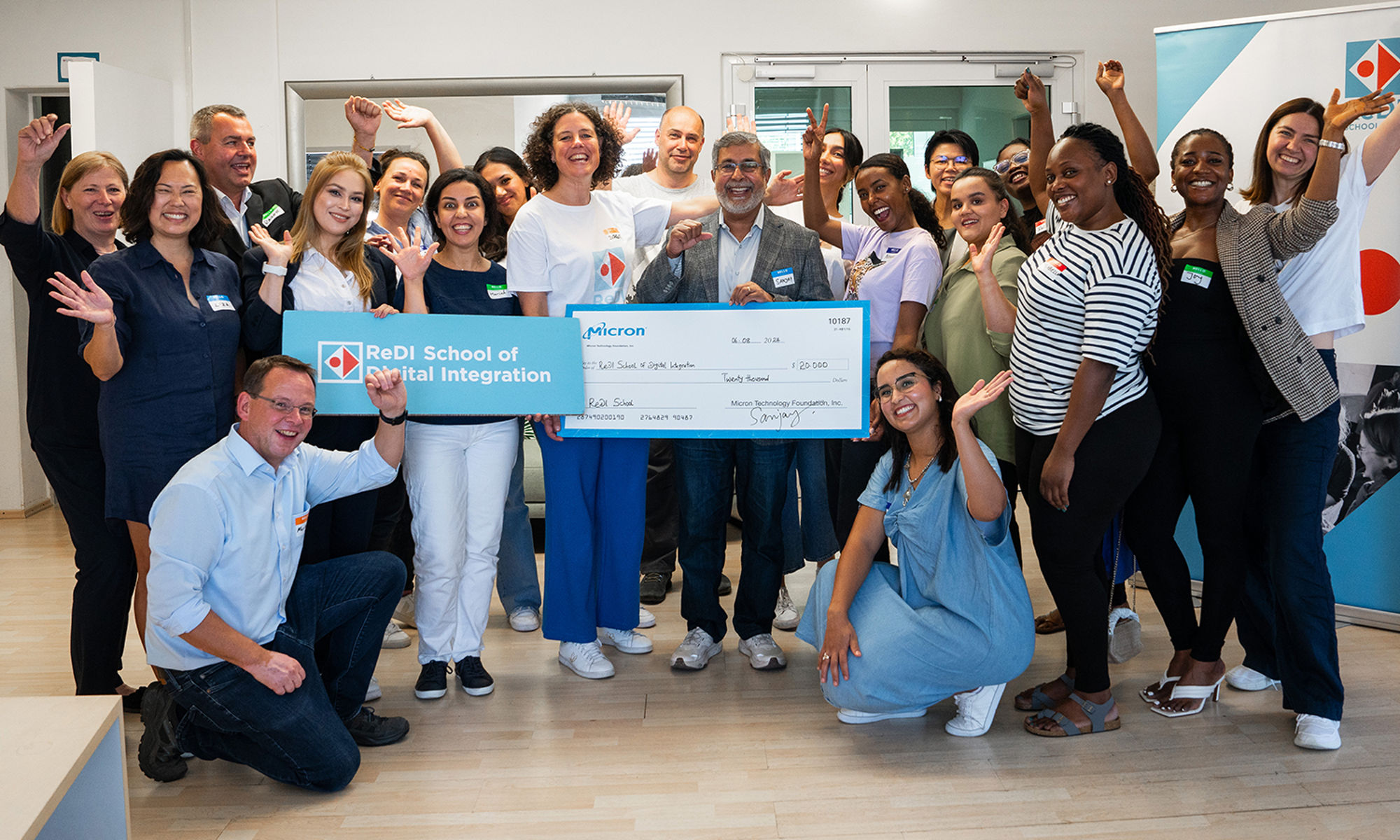 Micron Technology Chairman, President and CEO Sanjay Mehrotra presenting a check to a group of people at the ReDi school of digital integration