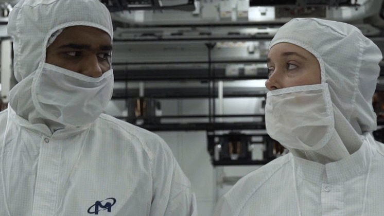 Two Micron clean room workers in a manufacturing environment