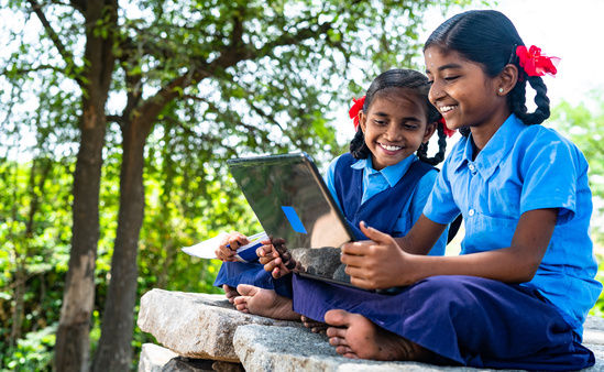handheld shot of Village school girl kids seriously busy working on laptop - concept of education, technology and knowledge.