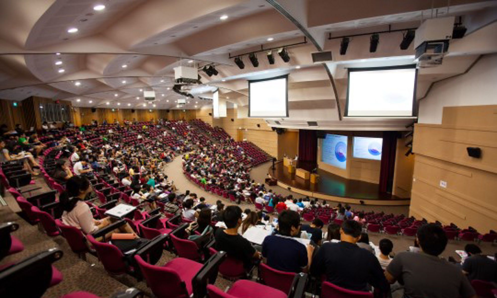 classroom auditorium full of students listening to a lecture