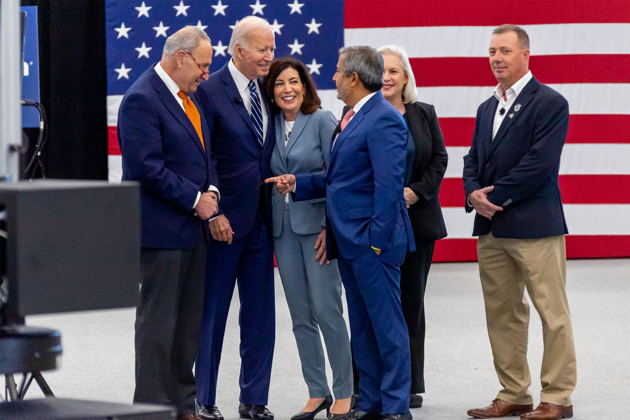 group of dignitaries having a chat with american flag in the background