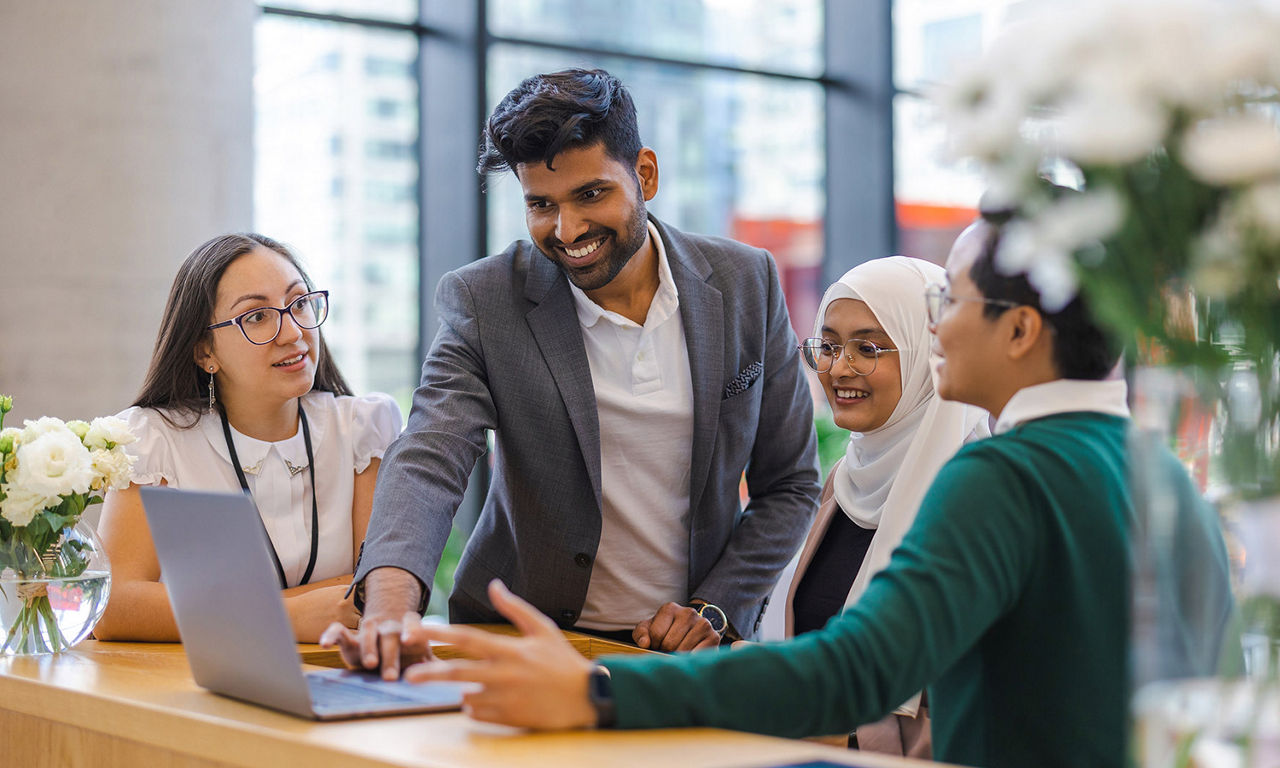 Group discussion around a laptop