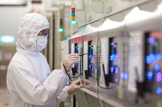 Women wearing a lab coat and operating the device with a pen like device in hand