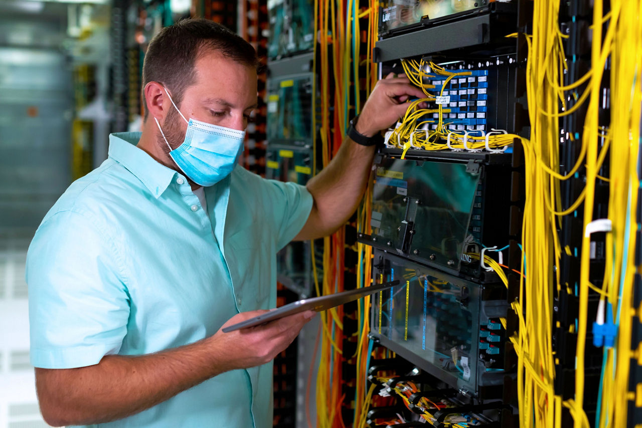 man wearing mask working on server