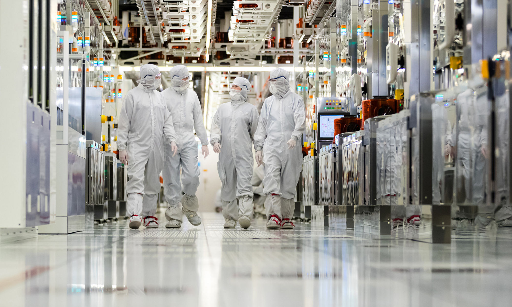 Clearn room employees walking down the hallway of a fabrication plant