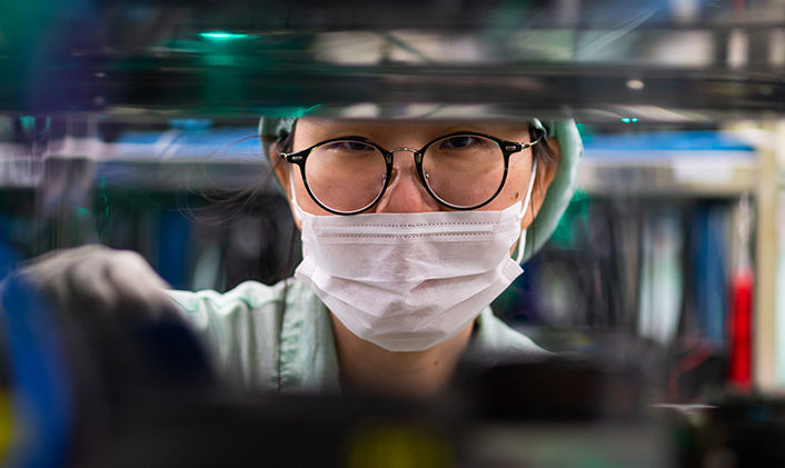 Close up of a Micron employee wearing a clean room suit and mask