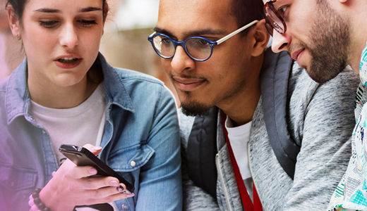 Three people looking at a mobile phone