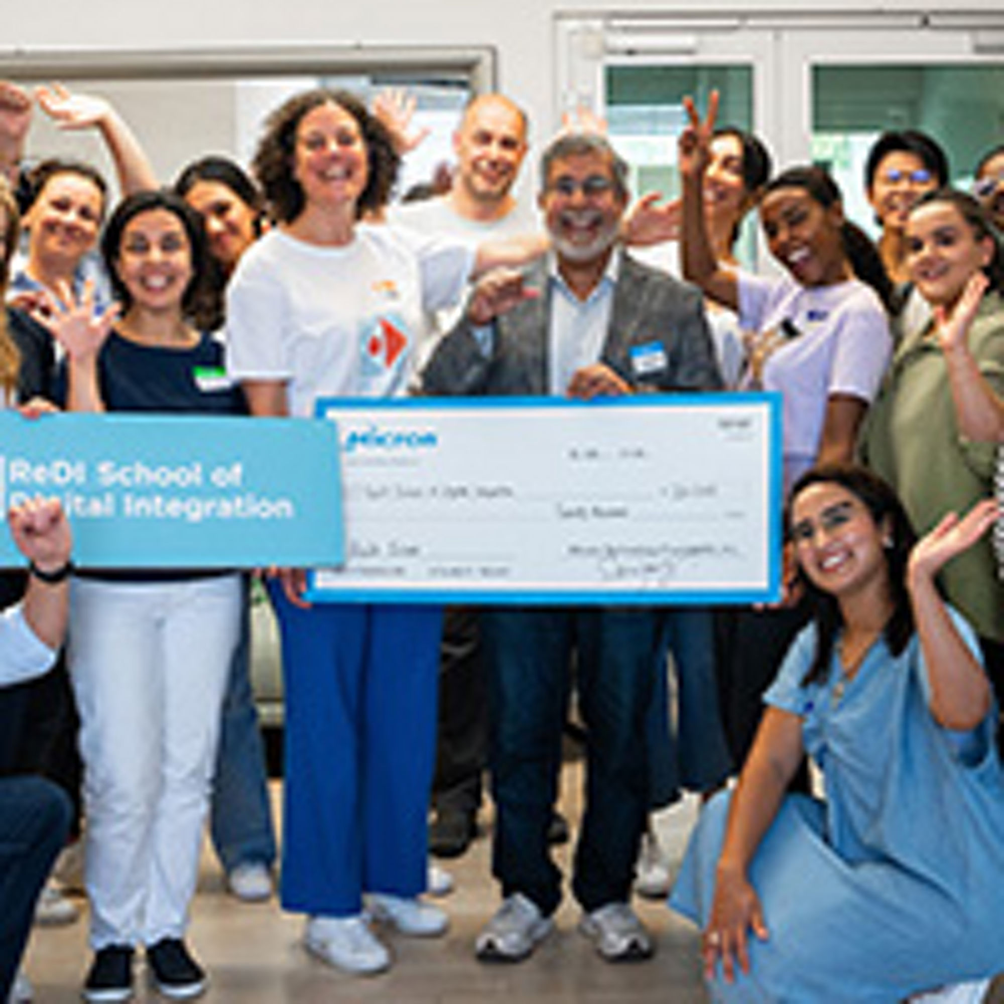 group of people holding standing together and holding a cheque with sanjay mehrotra the CEO standing in the middle