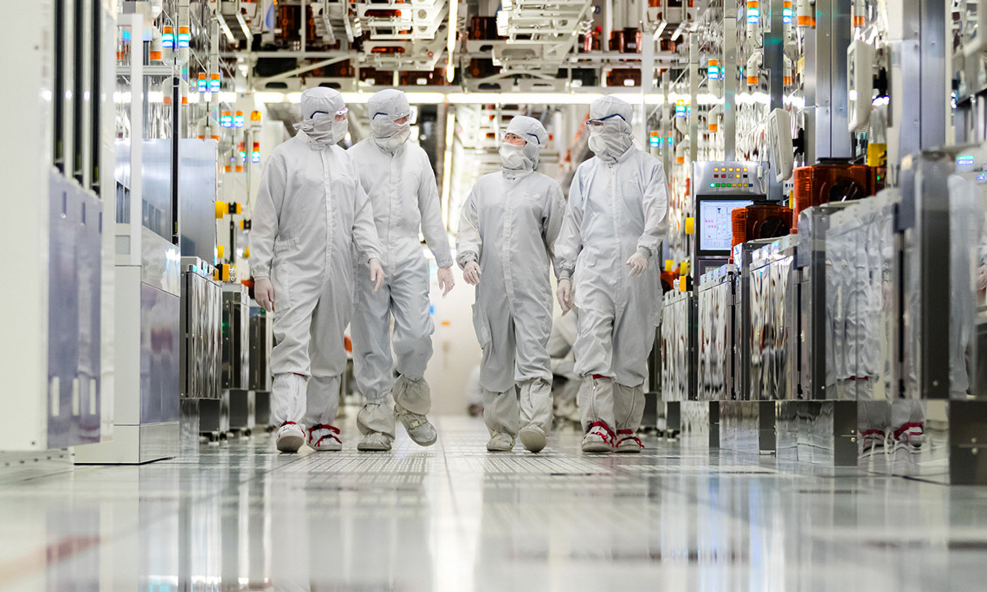 Clearn room employees walking down the hallway of a fabrication plant