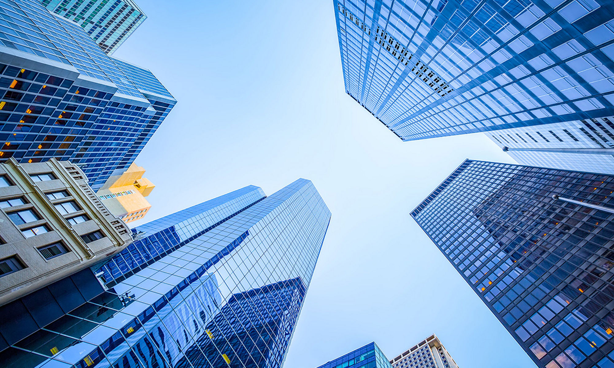 Ground view looking up between skyscrapers