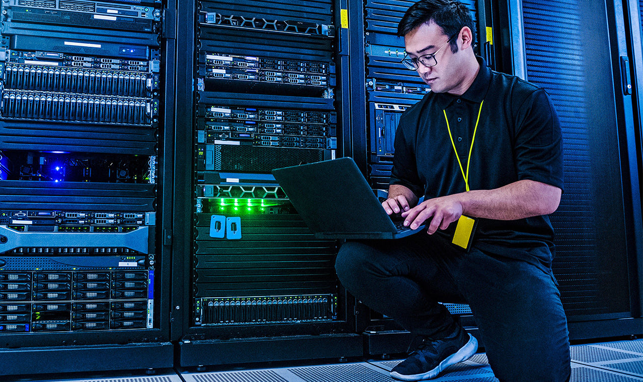 Employee working on server rack in data center