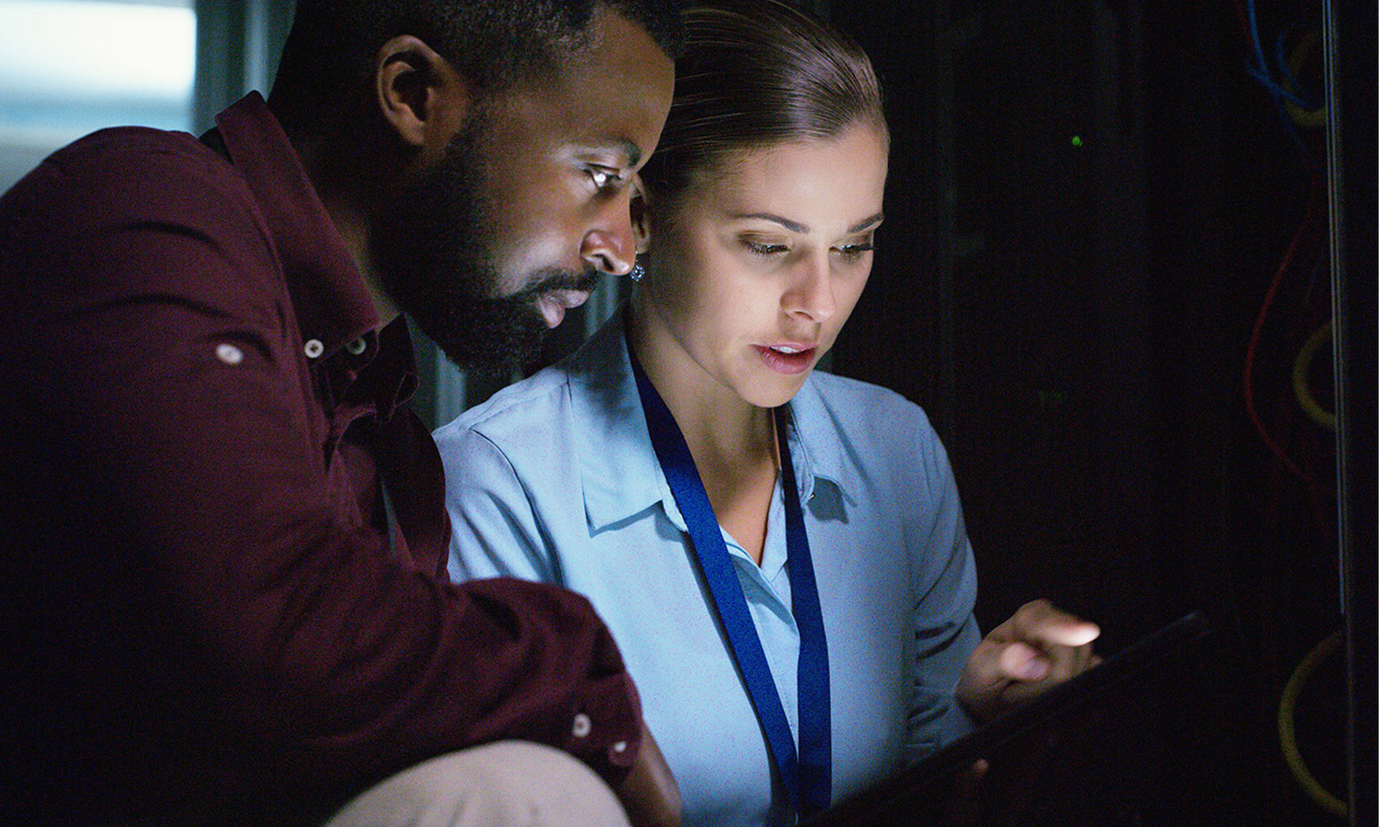 Two co-workings looking over a screen, working together.