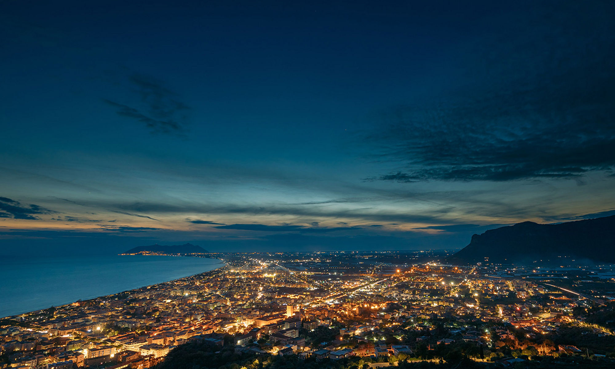 Aerial view of city by the sea at night