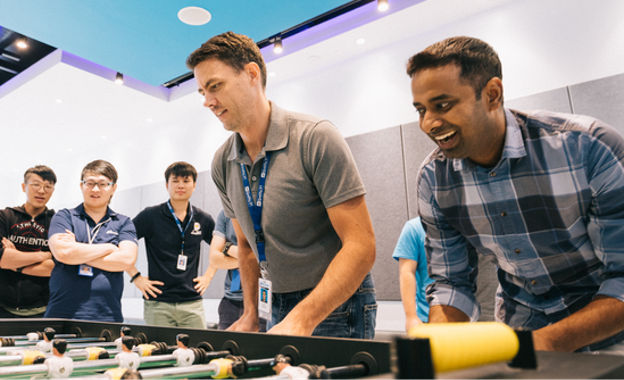 group of employees playing foosball