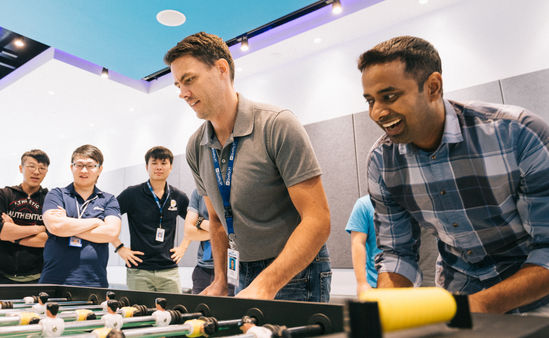 group of employees playing foosball