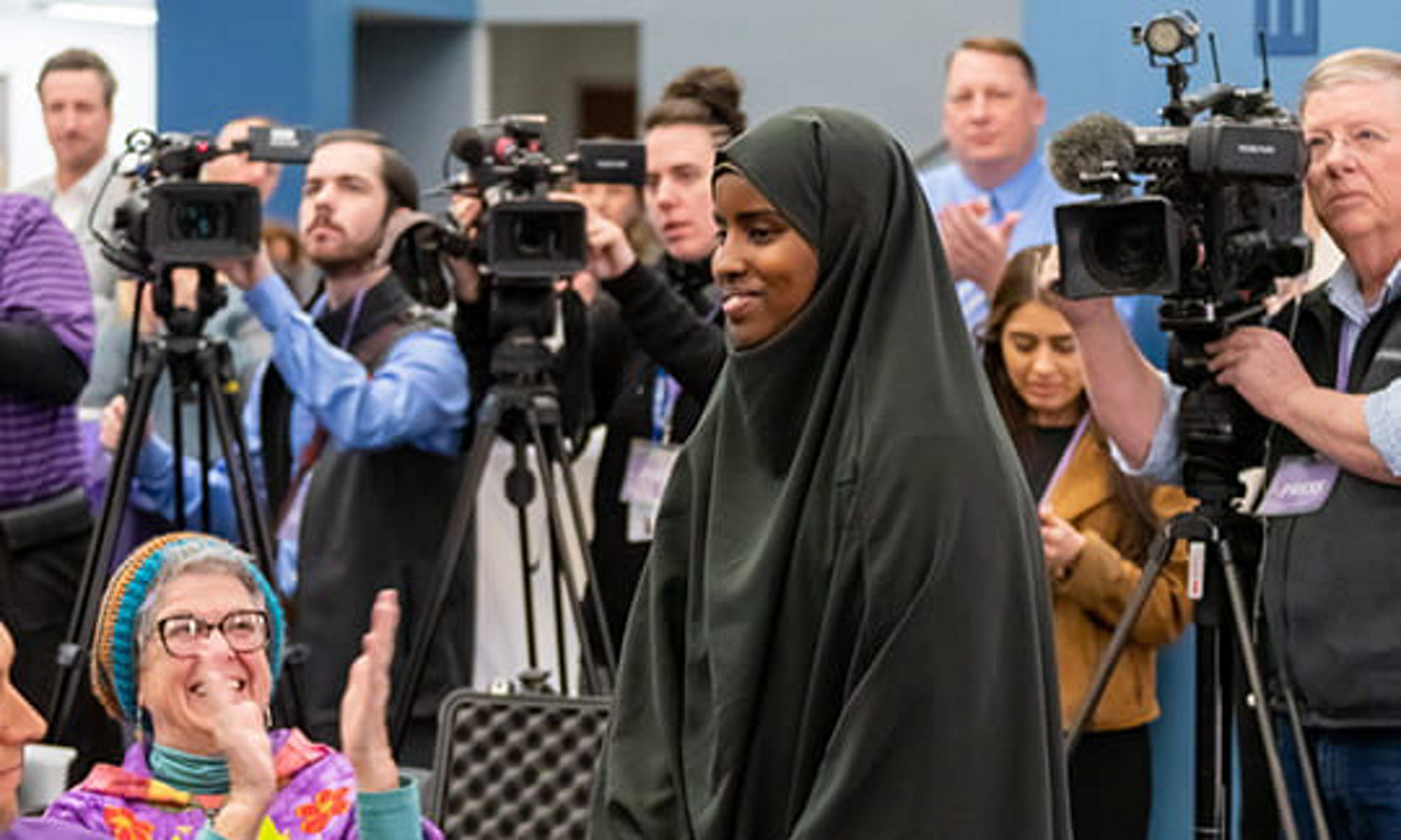 式典で歩く笑顔のムスリム女性